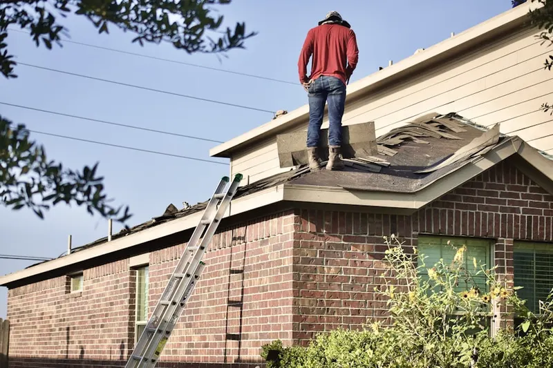 Professional roofer working on a residential roof in Baldwin Place